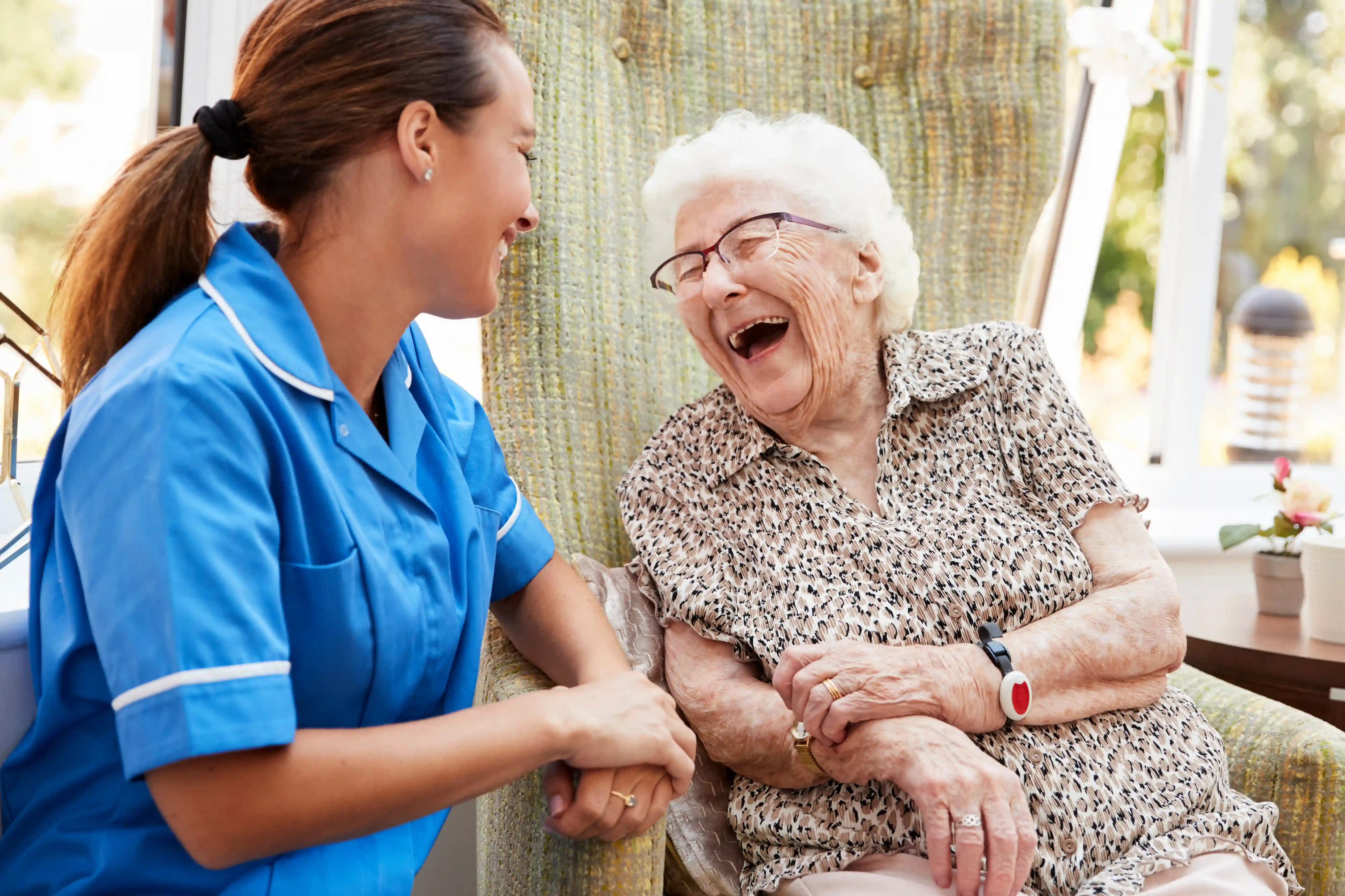 Caregiver's hands gently assisting a resident